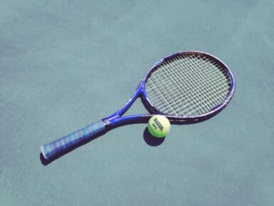 blue tennis racket and green Wilson ball